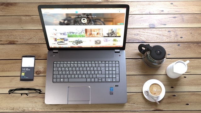 Notebook, mobil a káva položené na drevenom stole.jpg