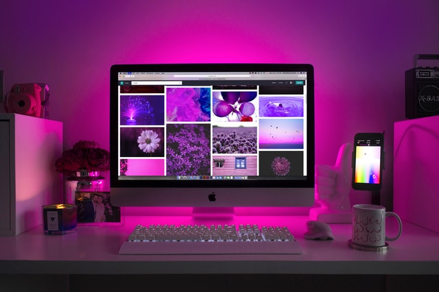 Počítač položený na pracovnom stole nasvietený na ružovo.jpg